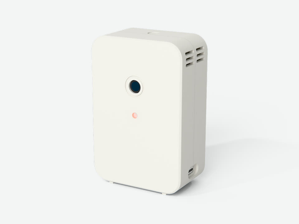 The RISE R-01: a small white printed slab with a single round camera eye on its face, an orange status light below it and vent slots high on its side.