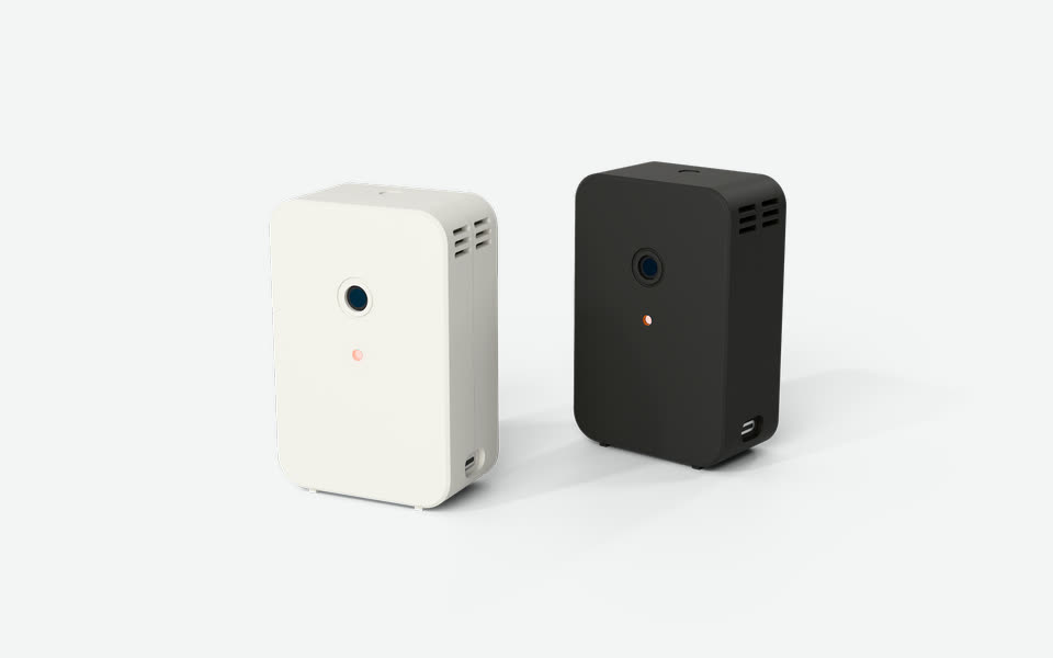 Two R-01s: one printed in Muted White in front, one in Charcoal Black behind it to the right.